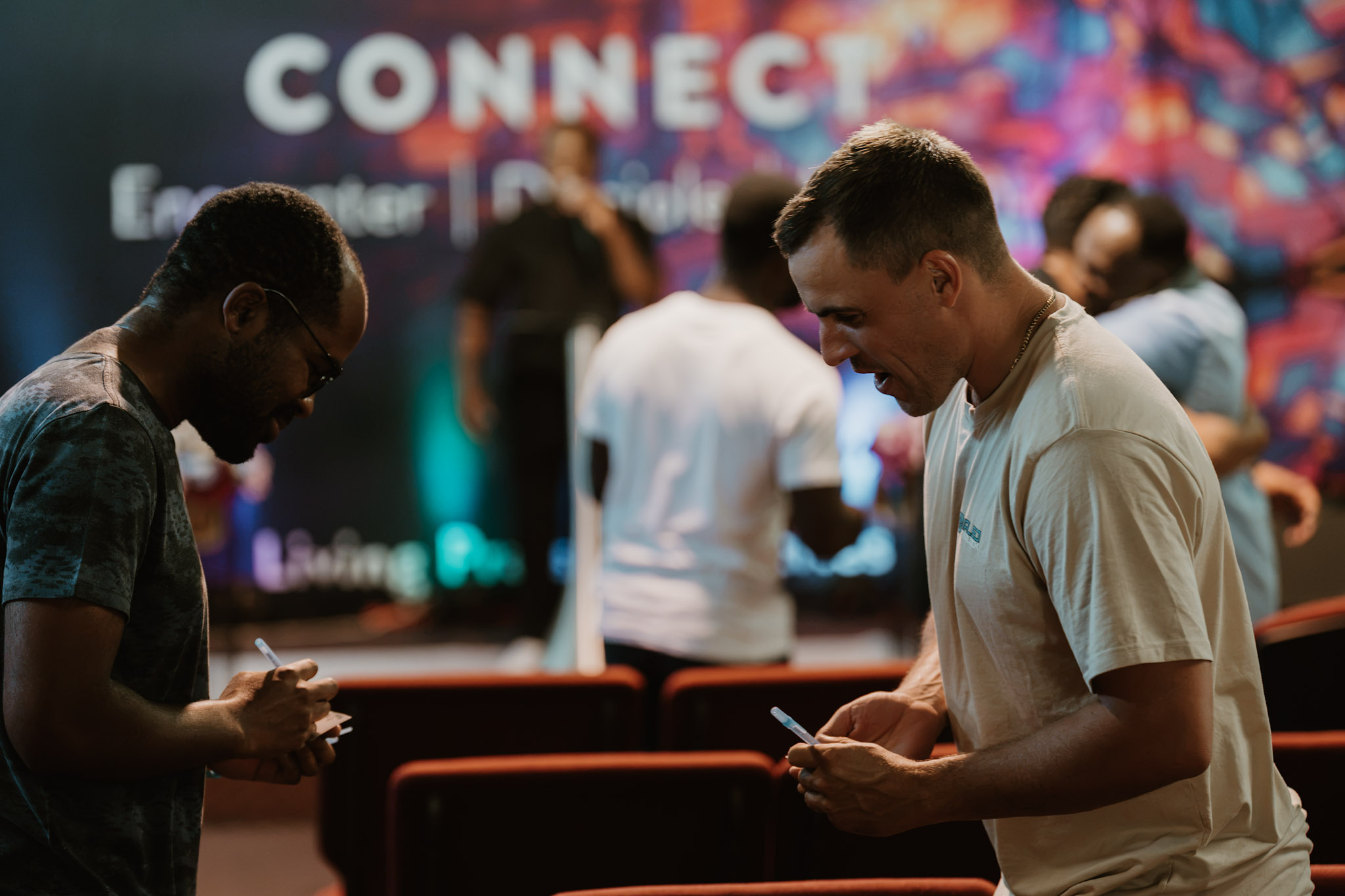 Two people exchanging details in front of the CONNECT backdrop